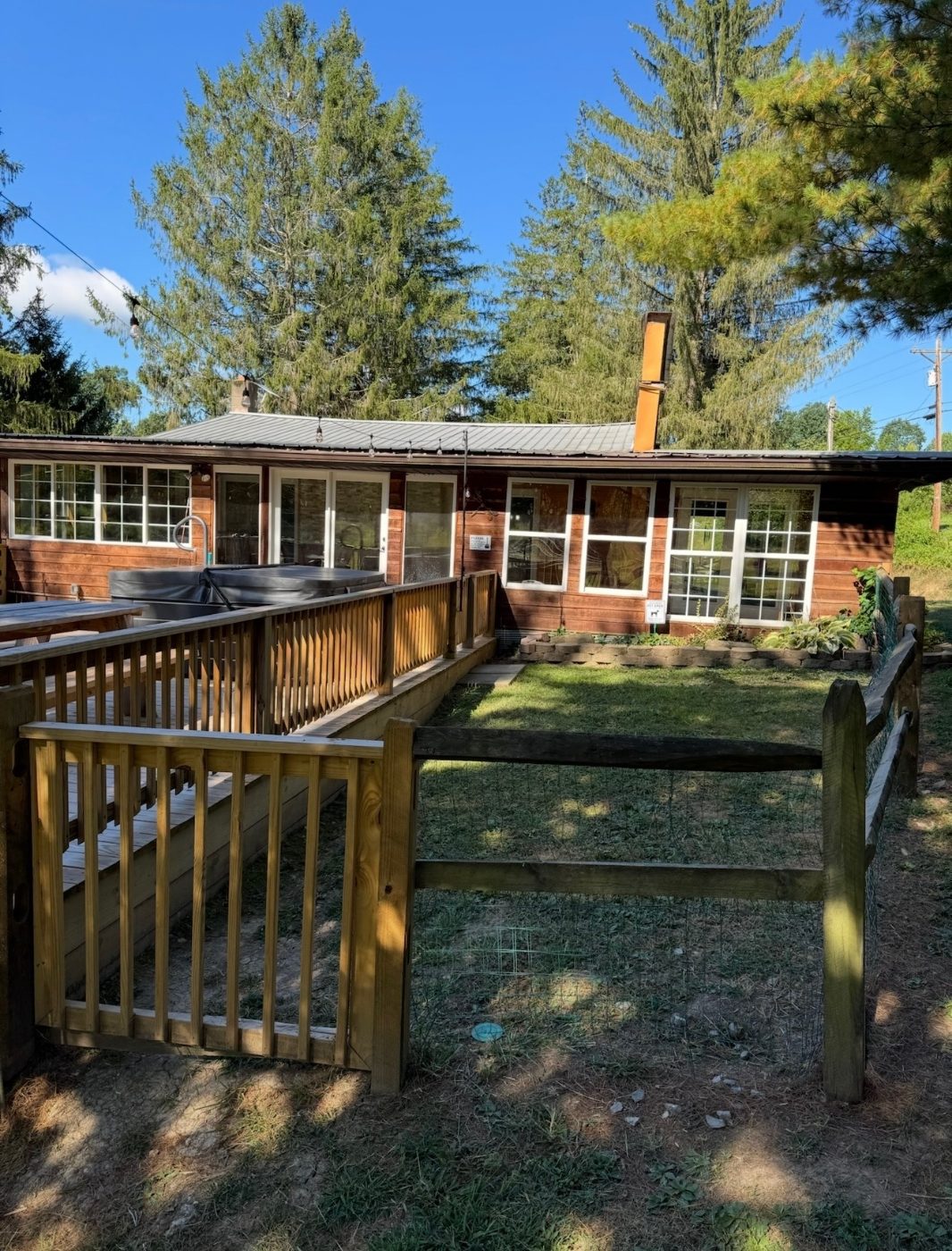 Fenced in pet relief area beside the deck and hot tub at Peaceful Pines Lodge