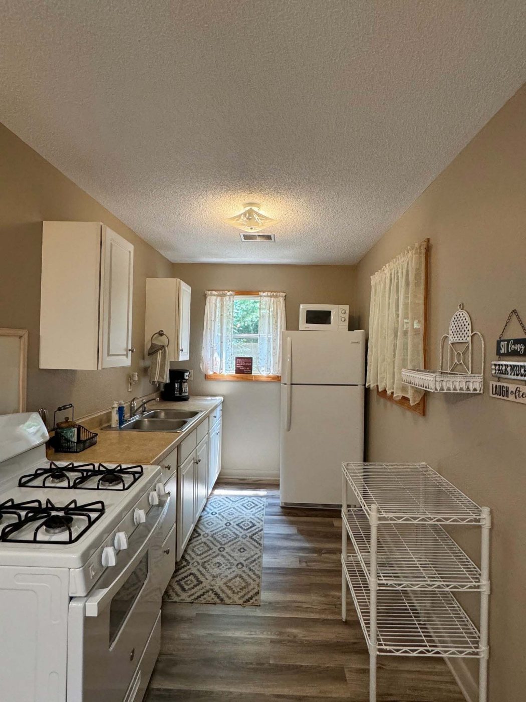 Fully equipped kitchen with gas range, refrigerator and coffee pot