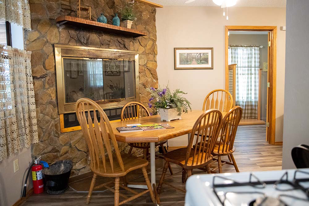 Dining roon with kitchen table and chairs and brick fireplace